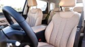 Interior of a car with beige perforated leather seats, steering wheel in foreground and headrests visible in the cabin