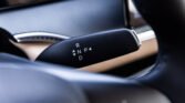 Close-up of an automatic gear shift with the letters R, N, P, D visible on the lever inside a car interior.