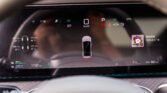 Digital car dashboard: speedometer shows 0 km/h, parked, EV indicator and OK light with various status icons