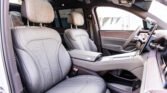 Interior of a luxury car: gray perforated leather front seats, center console, and sunroof visible.