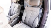 Gray perforated leather car seats with a center console visible, driver's seatbelt nearby, and protective coverings inside a clean SUV interior