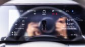 Infotainment car dashboard showing 0 km/h speed, parked gear, and tire pressure/readouts on the touchscreen field of view.