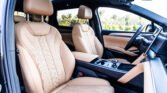 Tan leather car interior with front bucket seats and a center console view