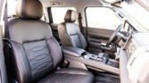 Inside view of a car cabin with black leather front seats, center console, and steering wheel visible.