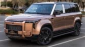 Bronze luxury SUV parked in a lot with black alloy wheels and palm trees in the background.