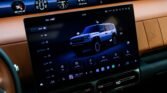 Large car infotainment touchscreen in a luxury interior, displaying a blue SUV graphic and Arabic menu icons.
