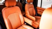 Orange leather captain seats with matching armrests inside a vehicle.
