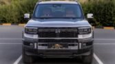 Front view of a silver pickup truck parked in a lot, featuring a bold black honeycomb grille and large bumper.