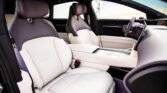 Luxurious car interior with white leather seats, center console, and steering wheel visible in a modern cabin.