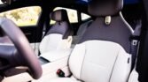 Interior of a modern car with white leather front seats and dark headrests, seen from the driver’s side window.