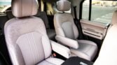 Light gray leather captain's chairs in the vehicle's second row with armrests.