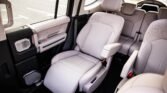 Interior of a spacious SUV showing light grey leather captain chair in the front with second-row seats behind them