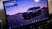 Infotainment screen showing a silver off-road SUV in a mountainous landscape.