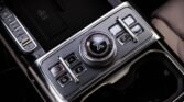 Center console with a large rotary control dial and square mode buttons in a luxury vehicle cockpit.
