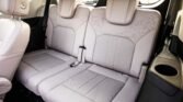 Light gray leather SUV rear seats with center armrest and built-in cup holder on the right side of the image.