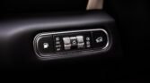 Car interior control panel for lights and features, including a rotating headlight/fog light dial and a left fuel-door release button on a glossy bezel