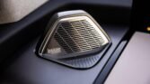 Close-up of a Lexicon by Harman car speaker embedded in a dark dashboard panel.