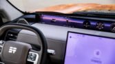 Interior of a modern car showing a curved, wide digital instrument panel across the dashboard and a large touchscreen on the center console.