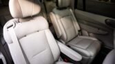 Interior of a car with light beige leather captain chairs and a center armrest area in view.