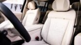 Cream leather car interior with perforated front seats, headrests, and center console visible in the cabin.