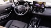 Interior of a modern car showing steering wheel, digital dashboard, and large infotainment touchscreen in the center console