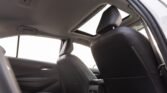 Rear interior of a sedan with black leather seats, headrests, and a sunroof open to the sky
