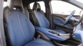 Blue upholstered front seats and center console of a modern car interior, driver’s side view
