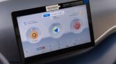 In-car touchscreen displaying three circular app icons on the dashboard (music/navigation widgets).