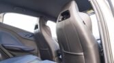 Interior of a car's back seat area with blue and black seats and a visible door panel with red stitching on the armrest