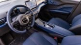 Blue automotive interior with a digital instrument cluster and a large central touchscreen on the dashboard, showing car controls and icons.