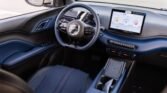 Interior of a modern car with blue leather seats, steering wheel, and a large dashboard touchscreen
